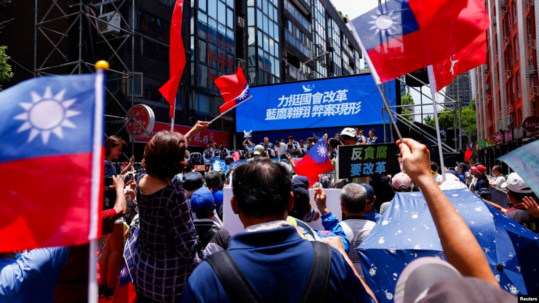 Partidarios del partido Kuomintang ondean banderas de Taiwán fuera del parlamento para mostrar su apoyo en Taipei, Taiwán, el 21 de junio de 2024.