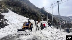 En esta imagen proporcionada por el ejército de la India, soldados despejan nieve de una avalancha cerca del paso de montaña de Nathu La, en el estado indio de Sikkim, el martes 4 de abril de 2023.
