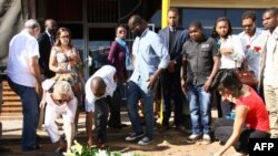 People lay flowers and pay their respects where constitutional law expert Gilles Cistac was murdered on March 3, 2015 in Maputo, Mozambique.