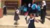 An Iraqi student holds Iraq’s flag in one hand and shows “V Sign” with her other hand ,Belqis Elementary School (right side of Mosul), July 18, 2017.