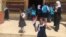 An Iraqi student holds Iraq’s flag in one hand and shows “V Sign” with her other hand ,Belqis Elementary School (right side of Mosul), July 18, 2017.