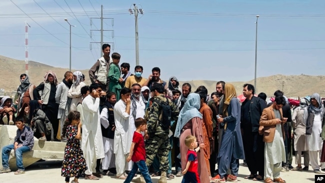 FILE - Hundreds of people gather outside the international airport in Kabul, Afghanistan, Aug. 17, 2021. Some of those unable to leave Afghanistan before the American military withdrawal included winners of the diversity visa program.
