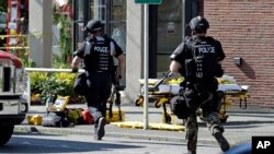 Polisi di Seattle berlari ke arah bangunan kampus menyusul penembakan di Seattle Pacific University (5/6). 