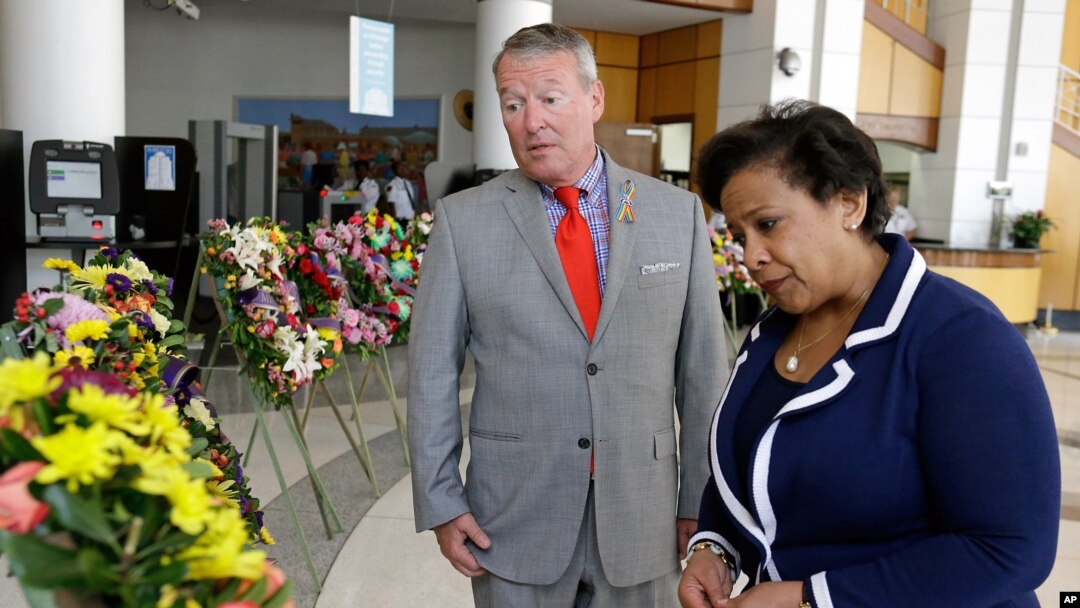 Orlando Mayor Buddy Dyer, left, and Attorney General Loretta Lynch view a memorial with 49 wreaths at City Hall, one wreath for each victim of the Pulse nightclub mass shooting in Orlando, Florida, June 21, 2016. 
