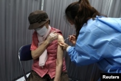 Seorang lansia Korea Selatan menerima dosis pertama vaksin virus corona Pfizer-BioNTech di pusat vaksinasi di Seoul, Korea Selatan, 1 April 2021. (Foto: via Reuters)