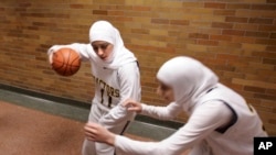 Pebasket putri Fordson High School Fatima Kobeissi, (11) bersama rekan setimnya Hyatt Bakri sebelum pertandingan basket melawan Willow Run di Dearborn, Michigan, 4 Desember 2007. (Foto: dok). FIBA mengumumkan jilbab akan diizinkan penggunaanya dalam pertandingan internasional.