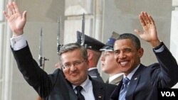 Presiden Barack Obama dan Presiden Polandia Bronislaw Komorowski melambaikan tangan ke arah kerumunan wartawan setibanya di Istana Presiden di Warsawa.