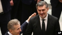 Georgian Dream party founder Bidzina Ivanishvili, left, embraces Georgian President-elect Mikheil Kavelashvili at his swearing-in ceremony at the Georgian Parliament in Tbilisi, Georgia, Dec. 29, 2024. 