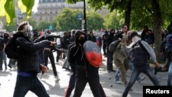 Masked youths face off with French police during a demonstration against the French labor law proposal in Paris, France, as part of a nationwide labor reform protests and strikes, April 28, 2016.