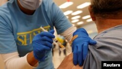 Seorang petugas melakukan vaksinasi COVID-19 di Chula Vista, California, Kamis 15 April 2021. 