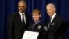 Vice President Joe Biden and Attorney General Eric Holder present the Medal of Valor to Officer Julie Olson of the Maplewood, Minnesota, Police Department, during a ceremony in the Eisenhower Executive Office Building on the White House complex in Washing