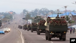 FILE - Congo military trucks carrying Congolese troops drive in a main street after violence erupted due to the delay of the presidential elections in Kinshasa, Democratic Republic of the Congo, Sept. 20, 2016.