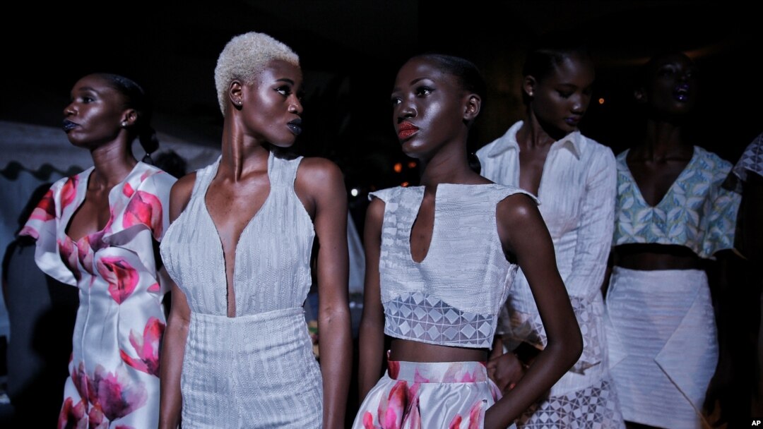 FILE - Models sit backstage during Dakar Fashion Week in the Senegalese capital, June 30, 2017.