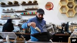 Ibrahim Alhasbani, owner of Qahwah House, a cafe that serves coffee made from beans harvested on his family's farm in Yemen's mountains, measures coffee beans in Dearborn, Michigan, Jan. 9, 2018.