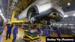 FILE - A battery is about to be installed on a electric car at a BYD assembly line in Shenzhen, China May 25, 2016. (REUTERS/Bobby Yip)