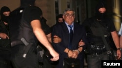 Extreme-right Golden Dawn party leader Nikolaos Michaloliakos is escorted by anti-terrorism police officers into a court house in Athens, Oct. 2, 2013.