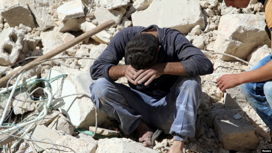 Seorang pria menangis berduka karena kehilangan kerabatnya dalam serangan udara di daerah pemberontak Aleppo, Suriah (11/10). (Reuters/Abdalrhman Ismail)
