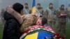 A Ukrainian serviceman bids farewell to his comrade Pavlo Vedybida at the Obolon Stadium in Kyiv, Ukraine, Nov. 30, 2024. 