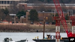 Recovery and salvage crews work near the wreckage of an American Airlines jet in the Potomac River near Ronald Reagan Washington National Airport, in Arlington, Virginia, Feb. 2, 2025.