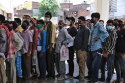 مردم در صف تست کووید۱۹ با ماسک ولی بدون رعایت فاصله‌گیری اجتماعی در شهر جامو، هند - ۱۹ آوریل ۲۰۲۱