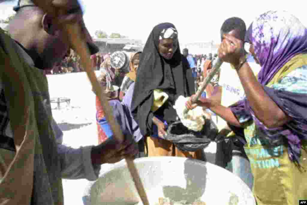 In this photo of Thursday Aug. 4, 2011, Somali mother of eight Halima Yusuf, receives emergency food rations at a World Food program site in the capital of Mogadishu on Thursday, Aug. 4, 2011. Yusuf was forced to leave her village after all her livestock 