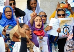 FILE - Women chant slogans during a demonstration calling for the repeal of family law in Sudan, on the occasion of International Women's Day, outside the Justice Ministry headquarters in Khartoum on March 8, 2020.