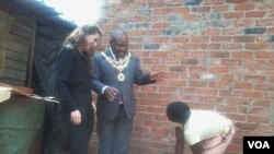 An official of the Bill and Melinda Gates Foundation and Harare mayor Bernard Manyenyeni talking to a local resident. (Photo: Irwin Chifera)