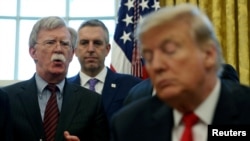 FILE PHOTO: U.S. President Donald Trump listens as his national security adviser John Bolton speaks during a presidential memorandum signing for the "Women's Global Development and Prosperity" initiative in the Oval Office at the White House in…