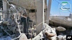 This citizen journalism image provided by Qusair Lens, which has been authenticated based on its contents and other AP reporting, shows a Syrian man checking his destroyed house that was damaged by a Syrian forces air strike in the town of Qusair, near th