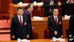 Presiden Xi Jinping dan PM Li Keqiang (kanan) menghadiri pembukaan sidang pertemuan tahunan parlemen China hari Senin (5/3). 