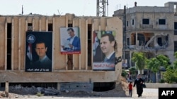 Портреты Башара Асада на здании избирательного участка в городе Дума, недалеко от Дамаска, 26 мая 2021 года