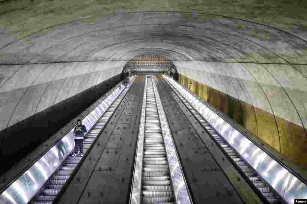 People descend on the escalator at the Bethesda Metro train station during commuter rush hour in Bethesda, Maryland, after Maryland Governor Larry Hogan ordered the shutdown of all bars and eateries in the state due to the coronavirus, March 16, 2020.