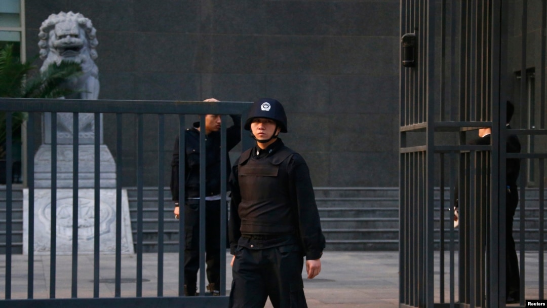 Security personnel stand guard outside as Chinese human rights lawyer Ding Jiaxi stands trial at a court in Haidian District, Beijing, April 8, 2014.