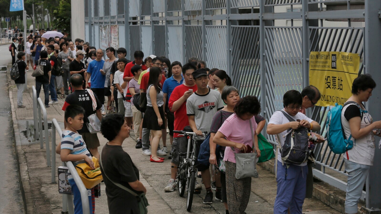 People line up at a polling center to vote in an unofficial referendum on democratic reform in Hong Kong, June 22, 2014. 