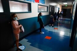 Los Angeles Unified School District students stand in a hallway socially distance during a lunch break at Boys &amp; Girls Club of Hollywood in Los Angeles, Aug. 26, 2020.