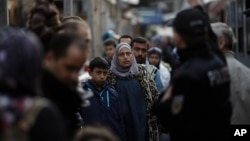 FILE - Refugees and migrants, mostly from Syria, arrive at the train station of the south German border town Passau on Sept. 16, 2015.