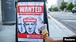 Un activista pega un cartel en la base de una farola en protesta contra la visita del primer ministro israelí, Benjamín Netanyahu, el 21 de julio en Washington.