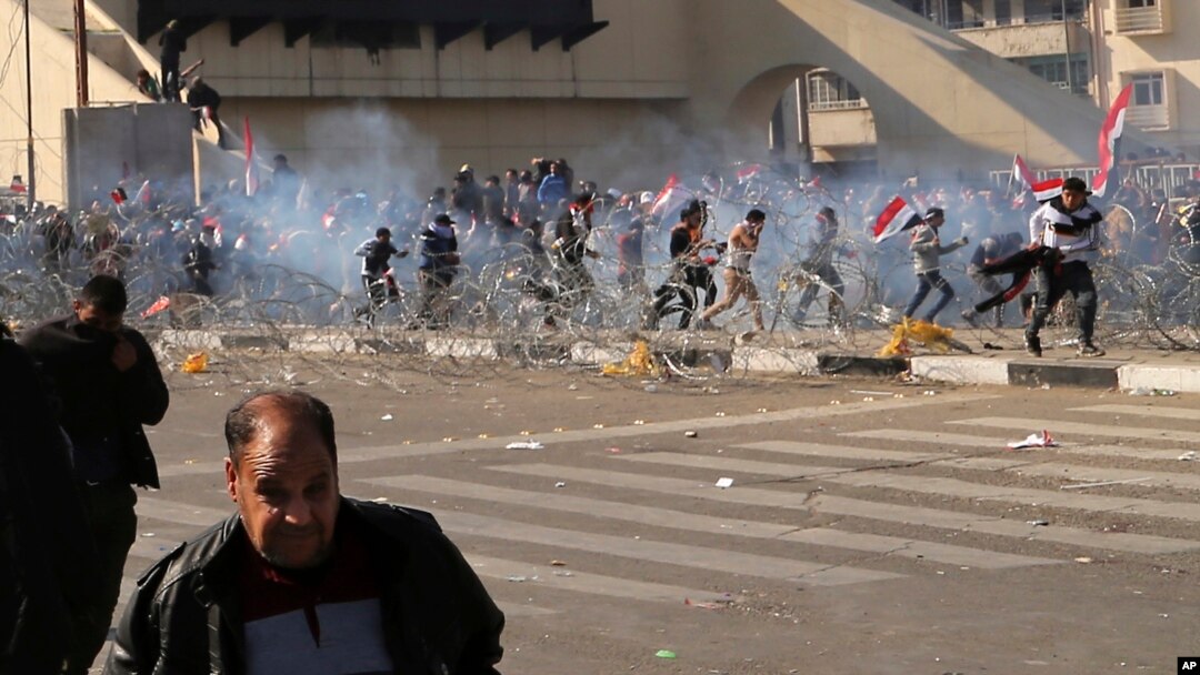 Người biểu tình chạy trốn khi cảnh sát bắn hơi cay vào đám đông tại thủ đô Baghdad, Iraq, ngày 11 tháng 02 năm 2017. 
