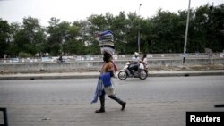 Un homme marche sur une route à Cotonou, Benin, le 5 mars 2016.