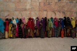 Wearing protective masks, women stand in line to enter the Grand Mosque of Touba as they take part in the celebrations of the Grand Magal of Touba, Senegal, Oct. 5, 2020.