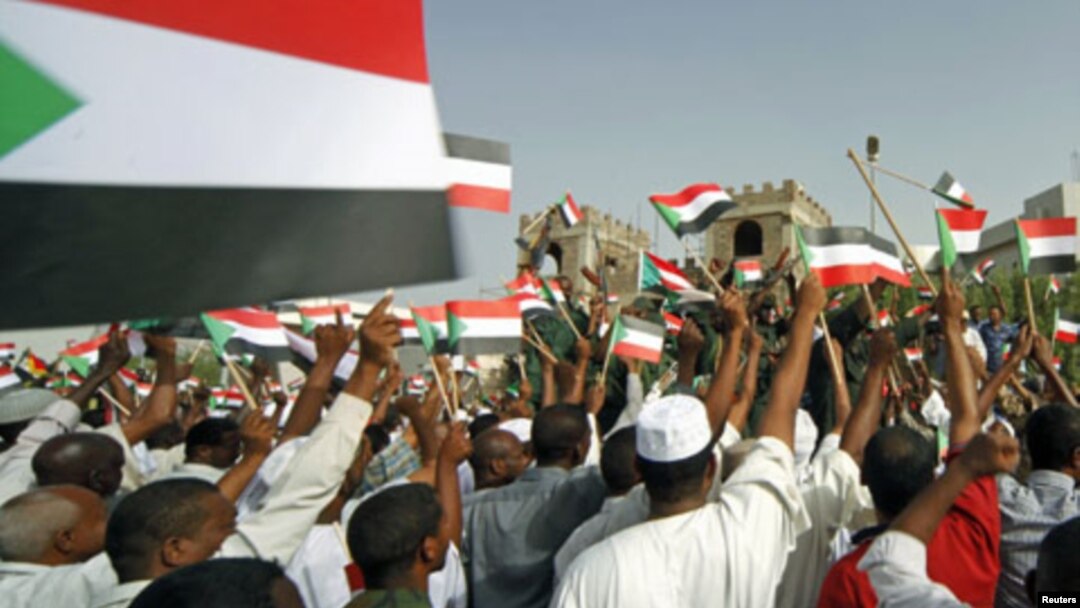 Mutane su na daga tutar Sudan ma sojoji a lokacin wani maci na murnar nasarar da suka samu a kofar ma'aikatar tsaro dake Khartoum ranar 20 Afrilu, 2012.