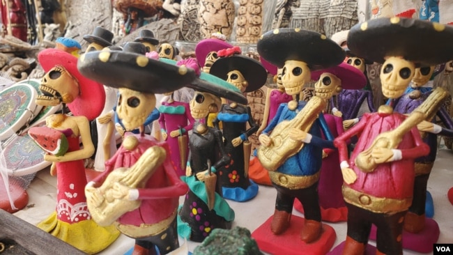 Figurillas mariachis, catrinas y calaveras decorativas para Día de Muertos en un puesto callejero en Ciudad de México previo a la celebración en la festividad el 31 de octubre de 2023. [Foto: Tomás Guevara, VOA].