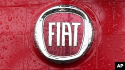 FILE - In this Jan. 2, 2014 file photo, a Fiat logo pictured on a car in Milan, Italy. Italian-American carmaker Fiat Chrysler Automobiles on Oct. 30, 2019, confirmed that it is in talks with French rival PSA Peugeot.