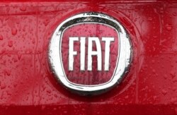 FILE - In this Jan. 2, 2014 file photo, a Fiat logo pictured on a car in Milan, Italy. Italian-American carmaker Fiat Chrysler Automobiles on Oct. 30, 2019, confirmed that it is in talks with French rival PSA Peugeot.