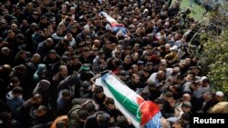 FILE - People carry the bodies during the funeral of Palestinians who were killed in an Israeli drone strike, in Tulkarm, in the Israeli-occupied West Bank, December 27, 2023