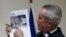 Paris prosecutor Francois Molins shows a photograph of the suspect gunman taken from surveillance footage during a news conference in Paris, Nov. 18, 2013. 
