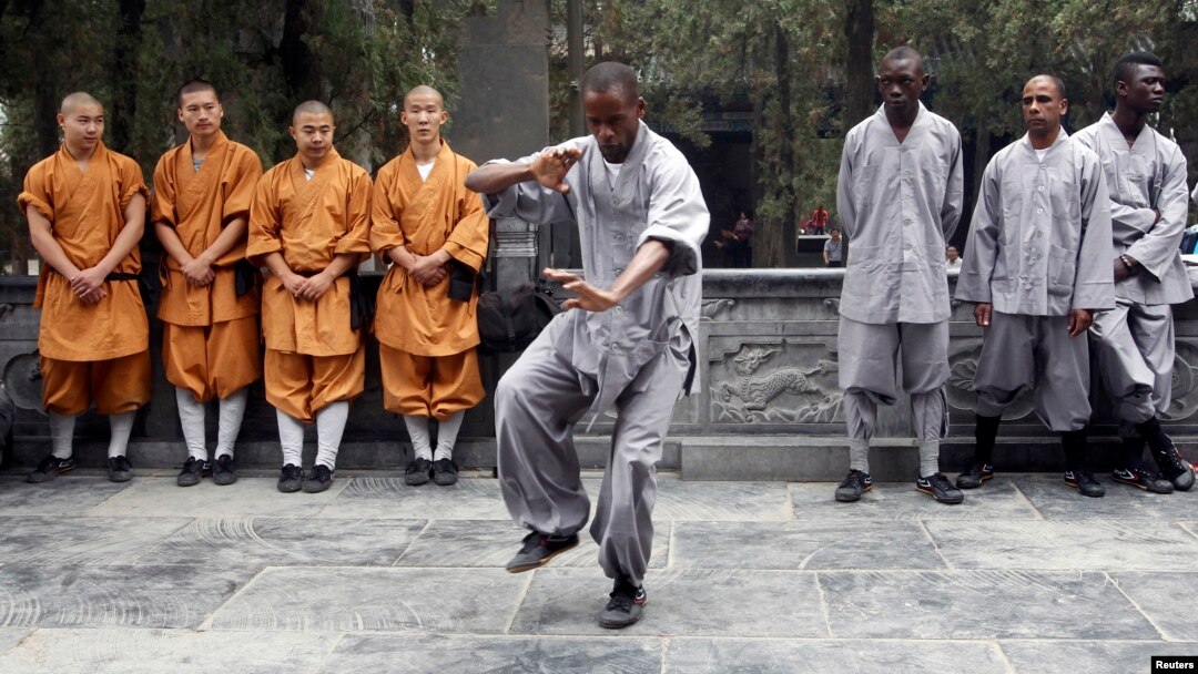 FILE - An African student practices moves as other Shaolin martial arts students look on during the inauguration ceremony of a martial arts training program for African students, at the Shaolin Temple in Dengfeng, Henan province, Sept. 2013. 