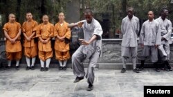 FILE - An African student practices moves as other Shaolin martial arts students look on during the inauguration ceremony of a martial arts training program for African students, at the Shaolin Temple in Dengfeng, Henan province, Sept. 2013. 