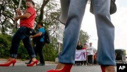 Male students and soldiers wearing high-heeled shoes pay tribute to women all over the world on the eve of the celebration of International Women's Day Monday, March 7, 2016.