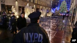 Policías vigilan la entrada al Centro Rockefeller en la Quinta Avenida de Nueva York. Las autoridades están en alerta después de que varias páginas web vinculadas al Estado Islámico publicaran una lista de iglesias para atacar en Estados Unidos.